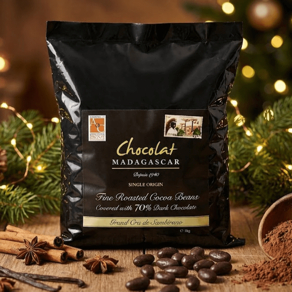 Chocolat Madagascar single-origin cocoa beans coated in 70% dark chocolate, 1 kg black premium packaging, product photo on wooden table with cocoa beans, cocoa powder, cinnamon, star anise and festive Christmas decoration.